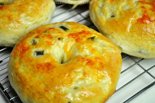 Jalapeño cheddar bagely na drátěném stojanu, připravené k jídlu.