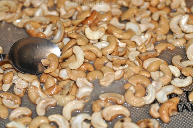 Coconut candied cashews are baked in oven.