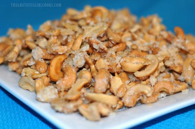 Coconut candied cashews, served on a white plate.