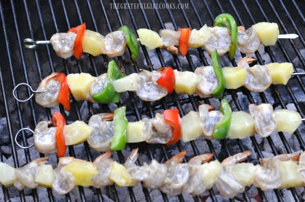 Shrimp, pineapple and peppers on skewers on BBQ