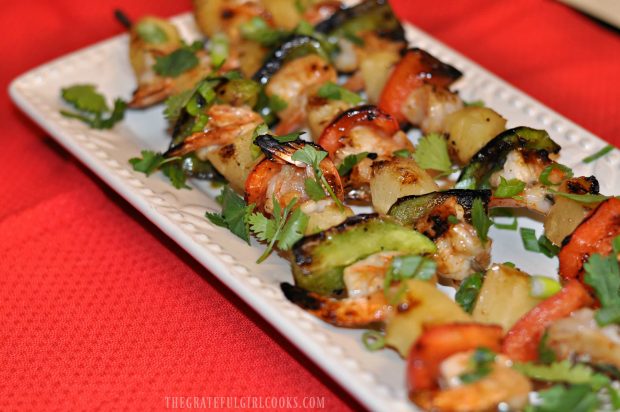Pineapple Coconut Shrimp Kabobs served on plate with cilantro garnish.