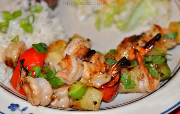 Pineapple coconut shrimp kabobs on plate, with rice on side