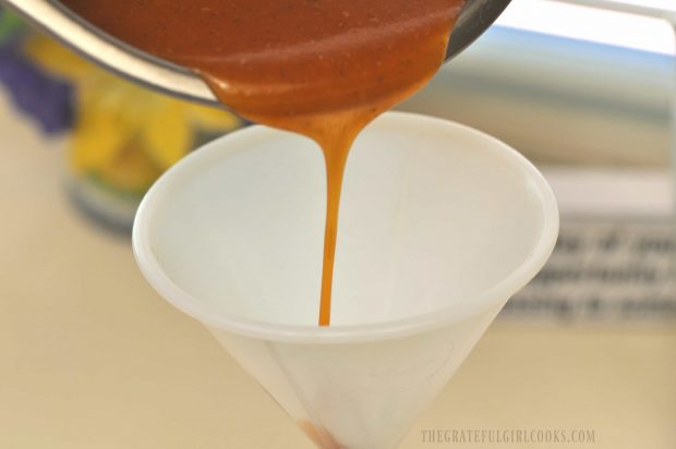 Catalina salad dressing is poured through a funnel into jar