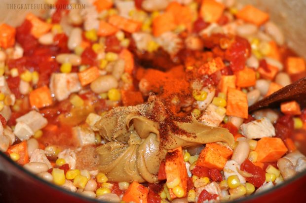 Spices, peanut butter, and tomato paste are added to the pot.