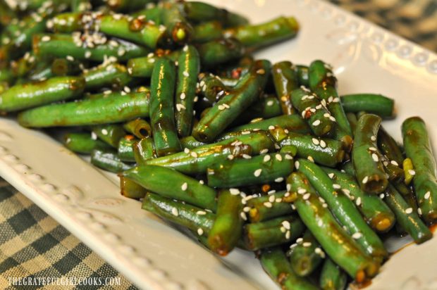 The spicy green beans are sprinkled with sesame seeds and served.