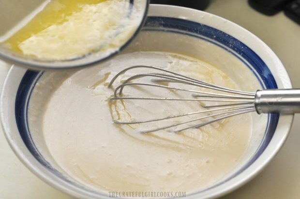 Melted butter is added to the cobbler batter in bowl.