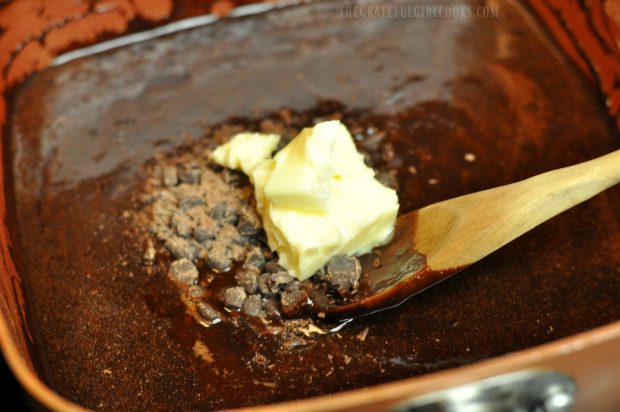 Butter and chocolate added to hot fudge sauce in pan