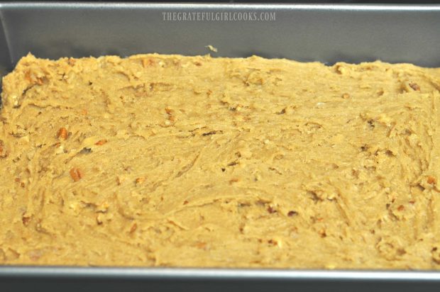 Dough for the pecan chewies is spread in a 13x9" baking pan.