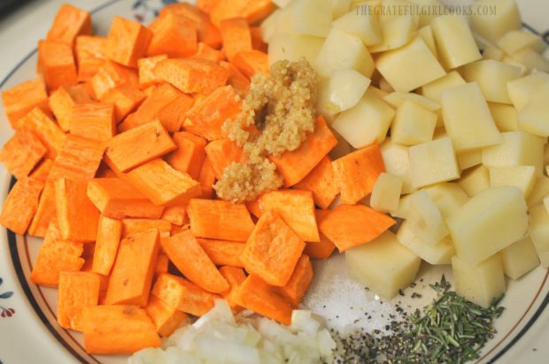 Russet and sweet potatoes on plate with herbs.