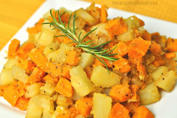 The finished potato hash is served with a sprig of fresh rosemary as garnish.