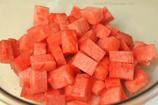 Cold watermelon melon is cut into chunks for the salad.