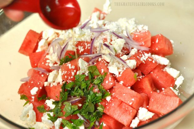 Olive oil, red onion, chopped mint leaves and feta cheese are added to the salad.