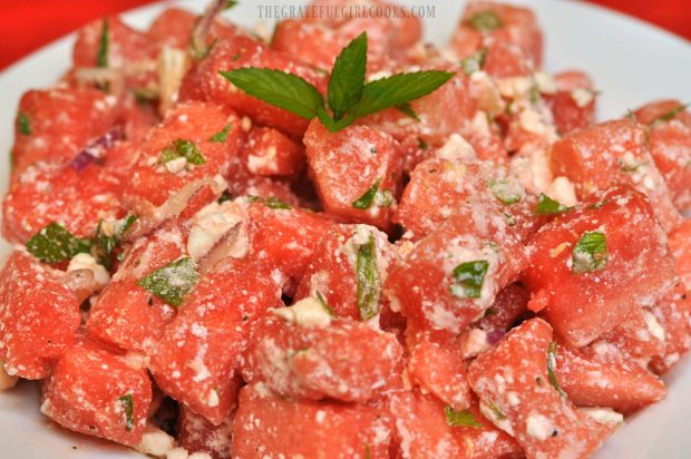 The cold watermelon feta mint salad is garnished with a mint sprig and served!