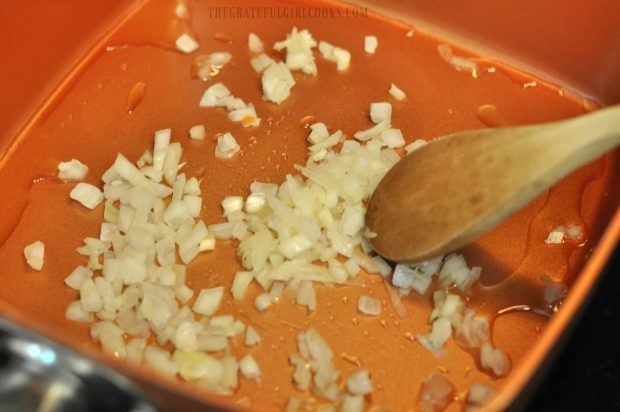 Cooking onions for the albondigas soup in a skillet.