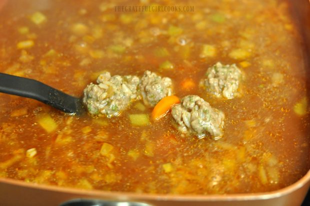 Stirring meatballs in soup