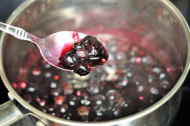 Thickened blueberries on spoon over saucepan