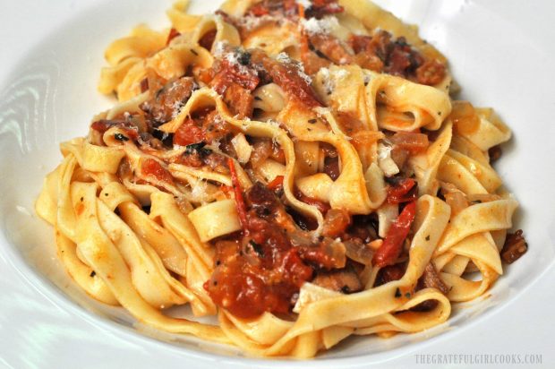 Close up photo to fettucine with bacon, tomato and onion Italian sauce.