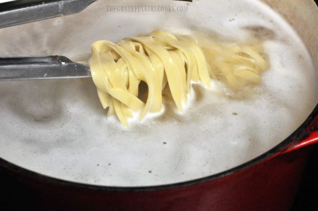 Fettucine noodles are cooked in boiling water until done.