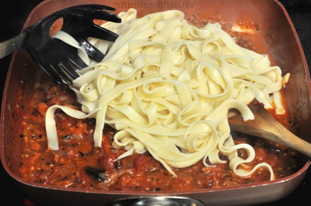 Cooked and drained fettucine noodles are added to tomato, bacon and onion sauce.