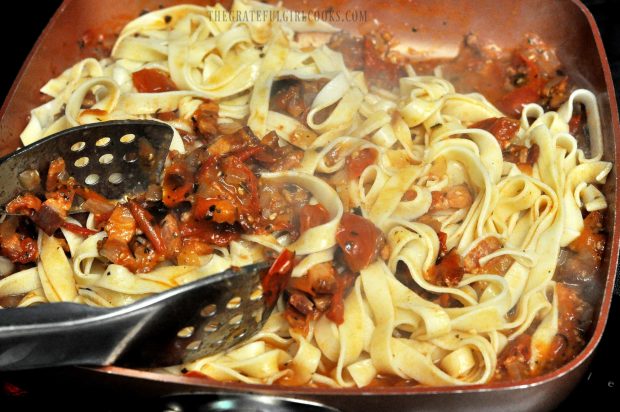 Tomato, bacon and onion sauce is stirred into cooked fettucine pasta.