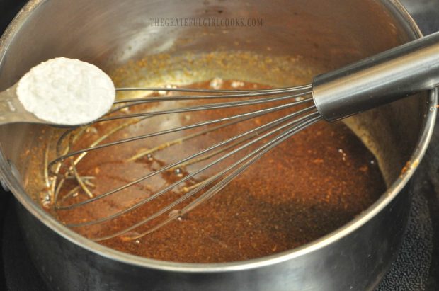 Cornstarch is whisked into homemade hoisin sauce in pan.
