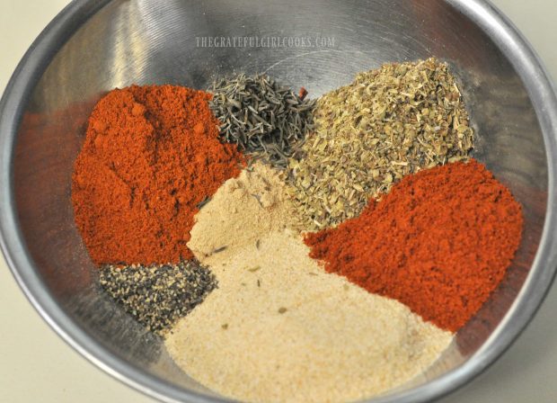 Spices used to make Cajun seasoning mix, in a bowl, ready to mix together.