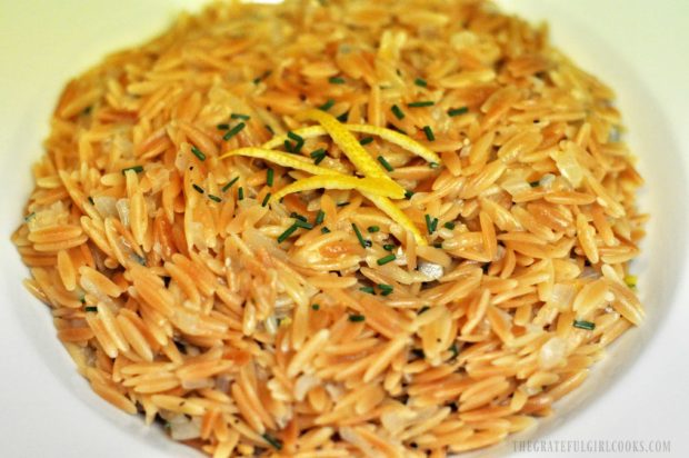 Toasted Orzo is served, garnished with chives and lemon peel strips.