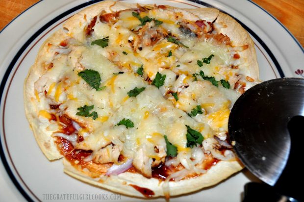 BBQ Chicken Tortilla Pizza is sliced with a pizza cutter.