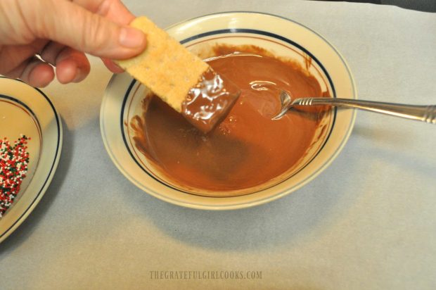 Dipping part of the shortbread cookie into chocolate.
