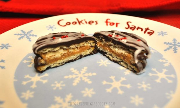 One of the Chocolate Covered Peanut Butter Ritz Cookies cut in half, on a Christmas plate.