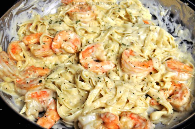 Garlic parmesan pasta and shrimp is garnished with parsley and served.