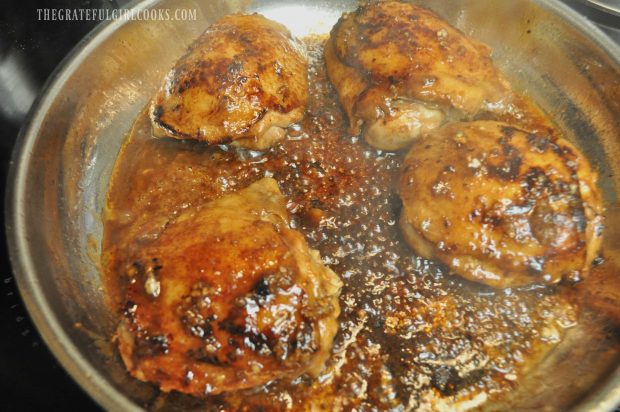 Hoisin Sriracha Chicken thighs are cooked in sauce in skillet.