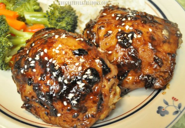 Two pieces of Hoisin Sriracha Chicken, on plate with broccoli on the side.