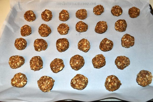 Pecan Pie Truffles are shaped into balls, then placed on parchment paper lined pan to refrigerate.