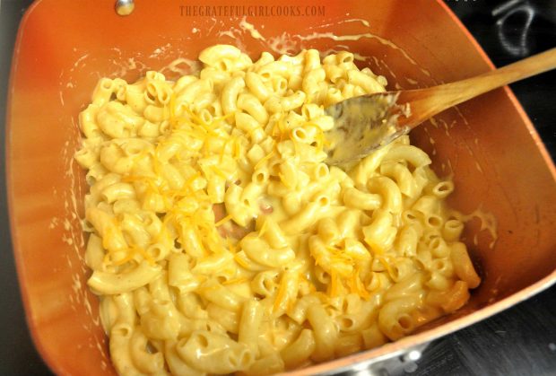 Macaroni and cheese is stirred well, to coat everything with sauce.