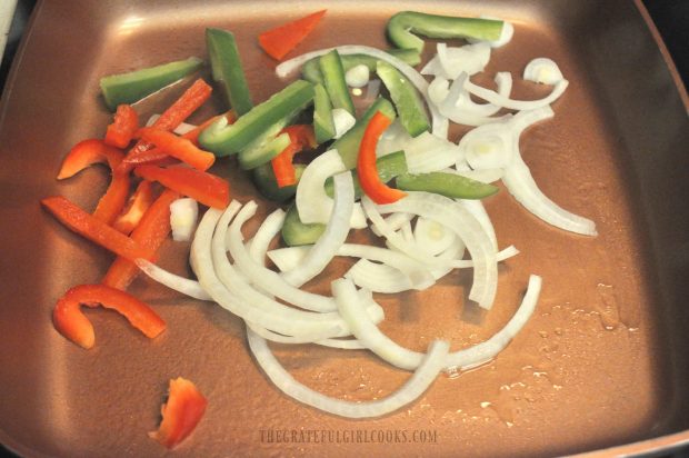 Cooking onions and peppers in a skillet, for the chicken fajita rice bowl.