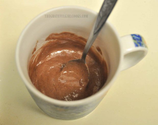 Ingredients for the mug cake are stirred together in the coffee cup before cooking.