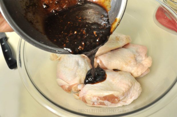 Marinade for Hoisin sriracha chicken is poured over the thighs.