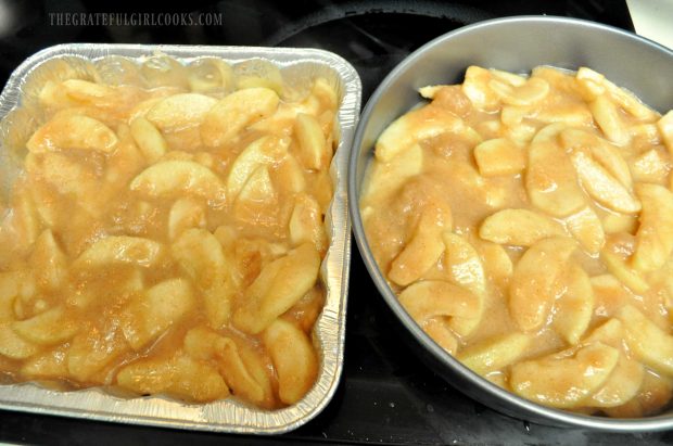 Apple pie filling is spread into baking pans.