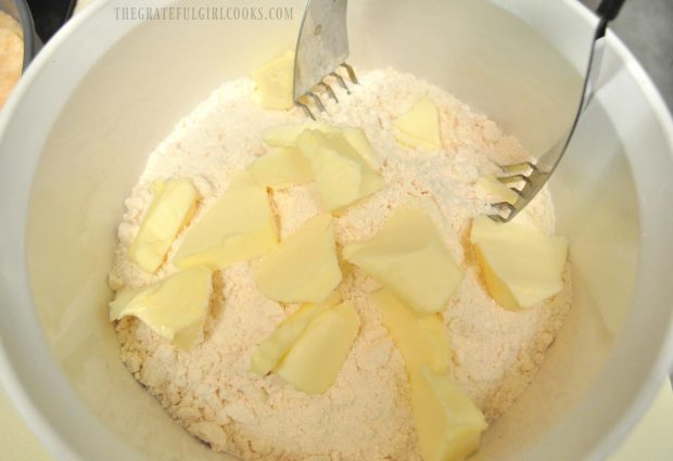 Butter is blended into dry ingredients using a pastry blender.