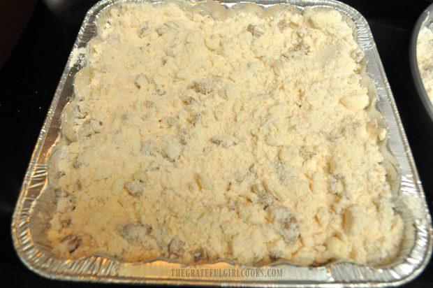 Crumb topping has been placed on top of the apple pie filling in baking pan.
