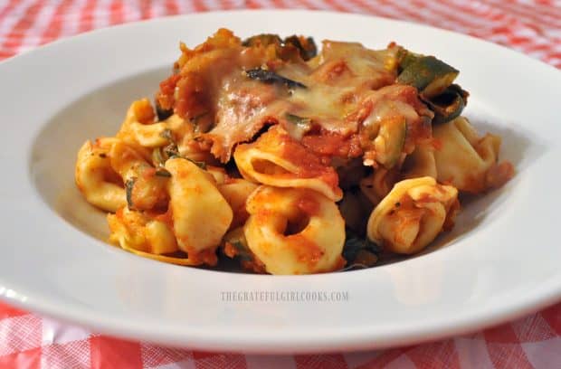 Cheese tortellini, marinara sauce and zucchini, in white serving bowl.