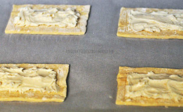 Cream cheese filling is placed onto puff pastry rectangles.