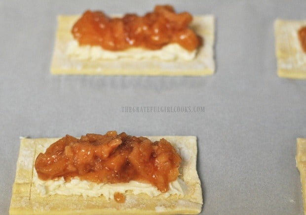 Apple pie filling is placed on top of cream cheese on pastry.