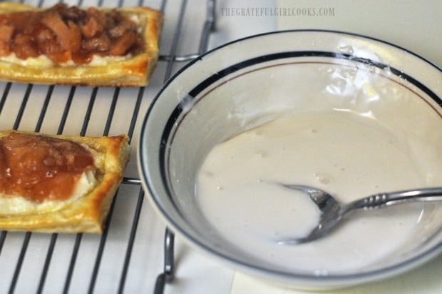 Powdered sugar glaze is prepared, to drizzle on top of apple cream cheese pastries.