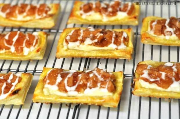 Apple cream cheese pastries are drizzled with powdered sugar glaze.