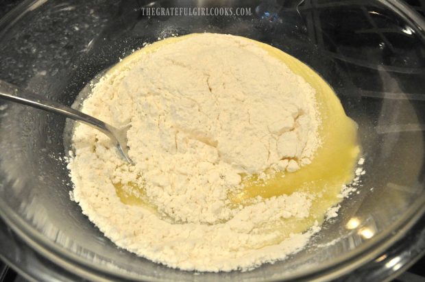 Yellow egg mixture added to flour in bowl