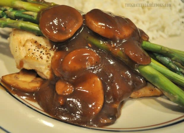 Chicken, covered with mushrooms and asparagus in balsamic sauce on plate