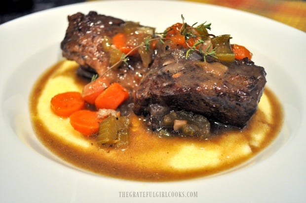 Short Ribs with Polenta, veggies and sauce in white bowl
