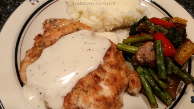 Chicken fried chicken and gravy, on plate with vegetables